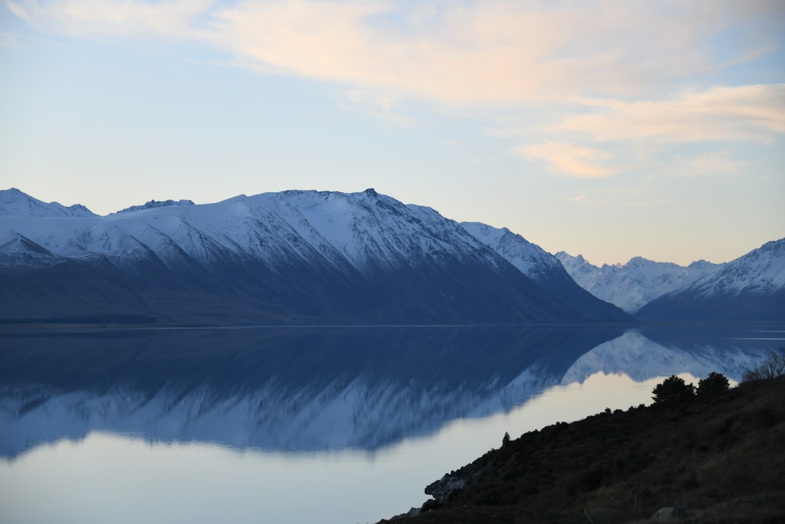 Snow-capped mountains reflected in Lake Tekapo, New Zealand